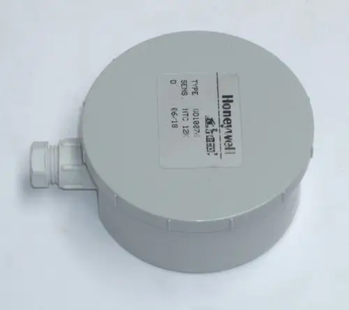 Graues Gehäuse eines Temperatursensors, möglicherweise von Daikin, mit Anschluss für Kabel und einem Aufkleber, auf dem technische Daten sichtbar sind.